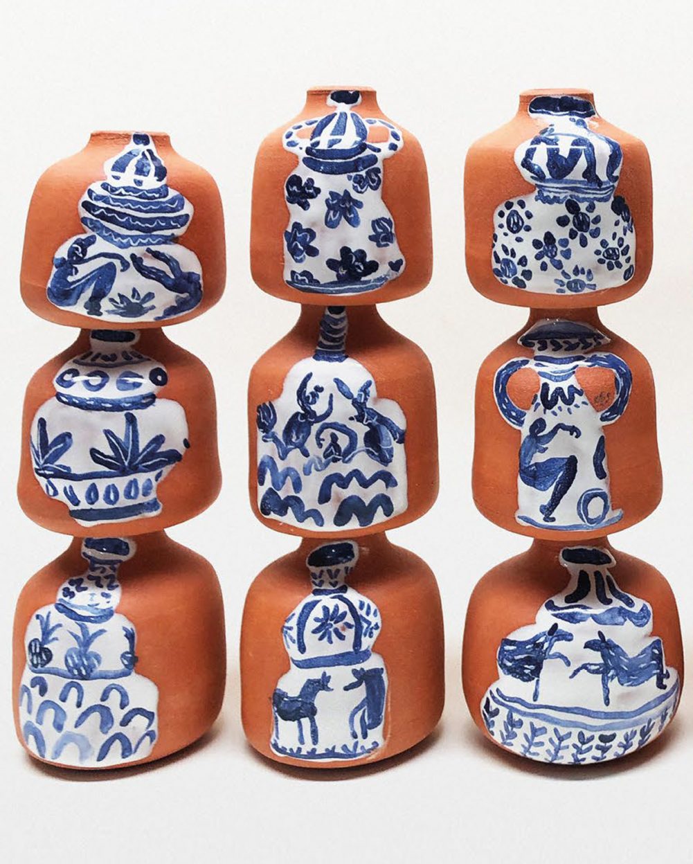 Ceramic pots with painted designs stacked on top of each other.