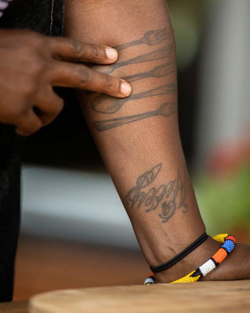 Arm tattoos of cooking utensils.