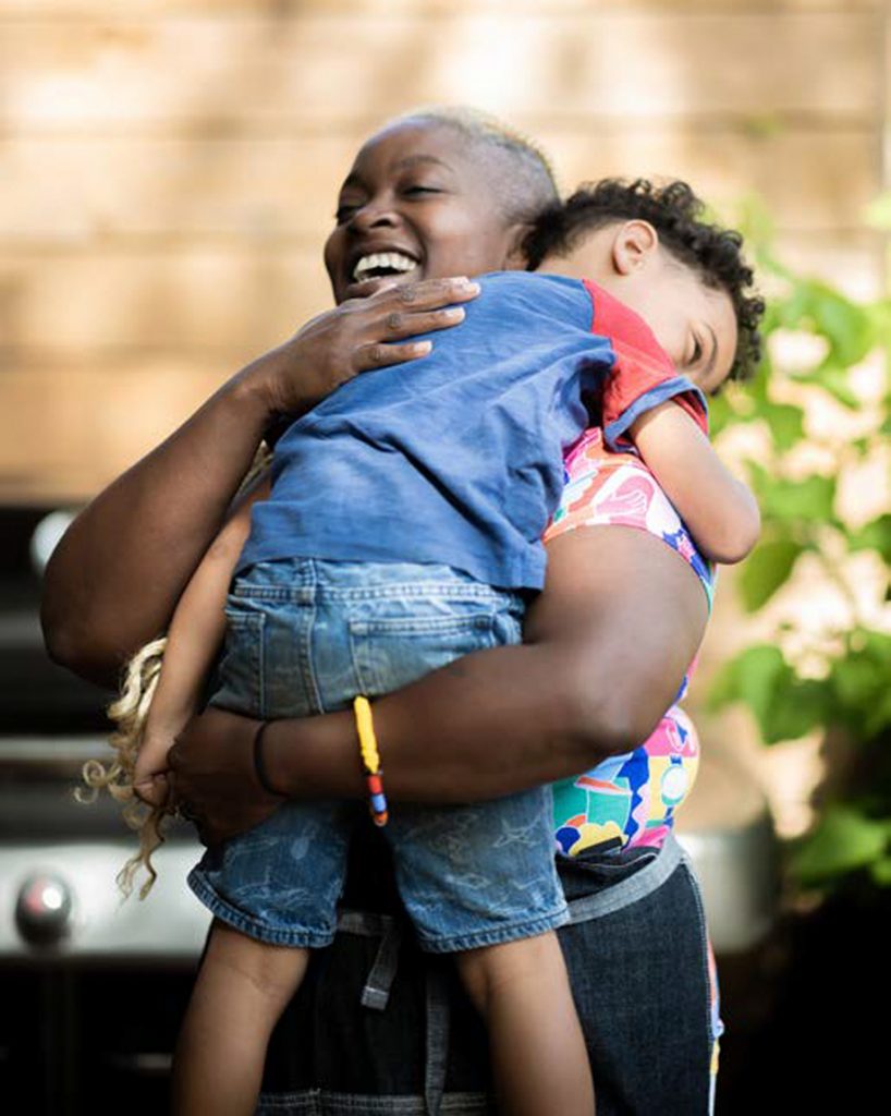 Barr hugging young son in arms.